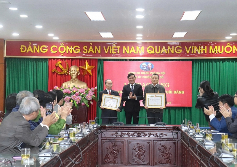 Phó Bí thư Thường trực Đảng uỷ phường Yên Sở Giang Chí Chung trao Huy hiệu Đảng cho đảng viên lão thành