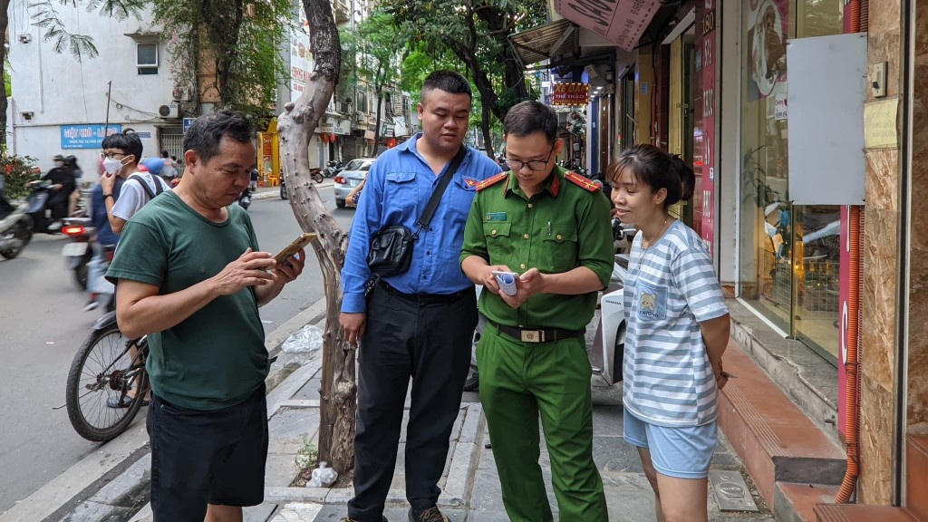 Người dân phường Thuỵ Khuê ủng hộ chiến dịch khi được thành viên tổ công tác Đề án 06 phường hướng dẫn sử dụng phần mềm