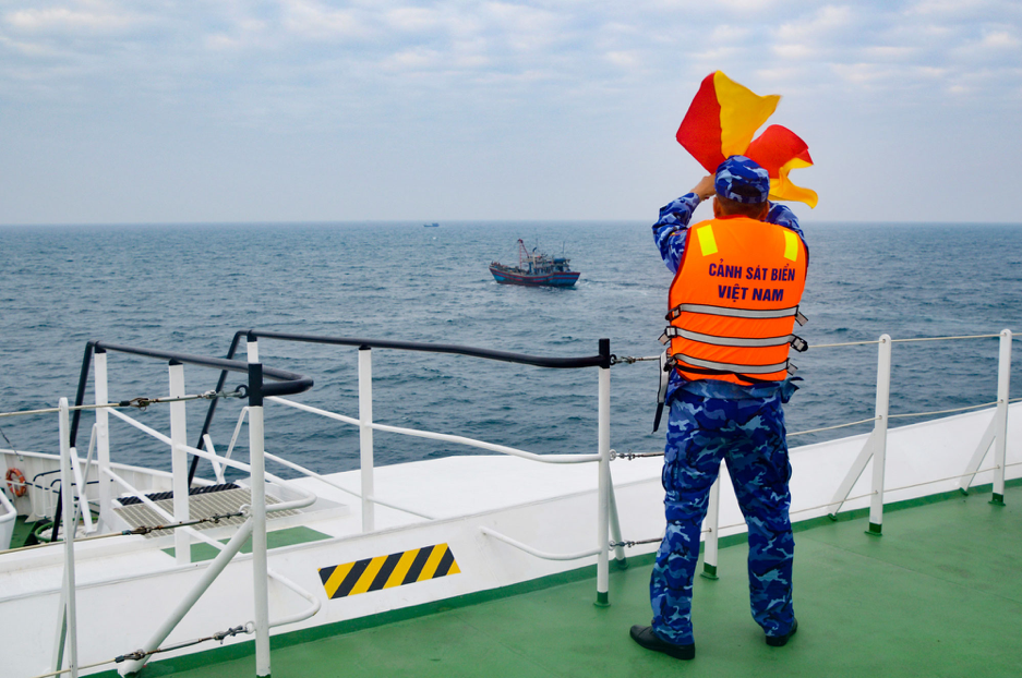 Ra tín hiệu cờ tay yêu cầu tàu cá Việt Nam chấp hành hiệu lệnh kiểm tra. 