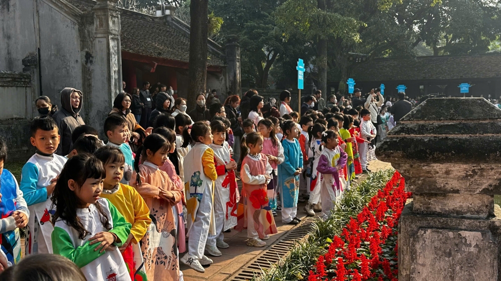 Khách Tây thích thú với hình ảnh học sinh mặc áo dài, đồng diễn tại Văn Miếu – Quốc Tử Giám