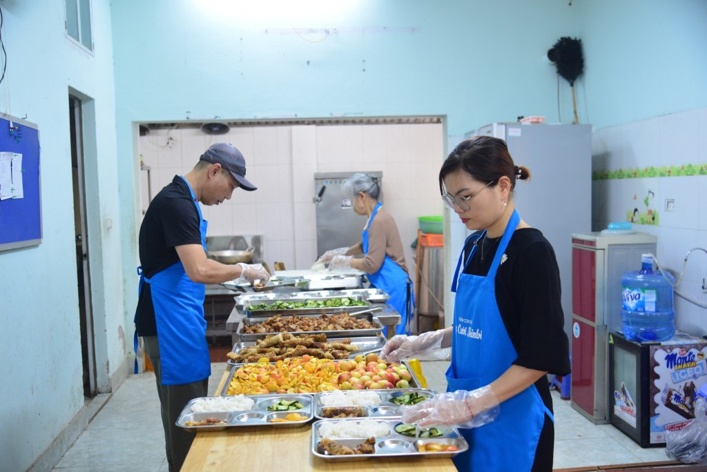 Chị Nguyễn Trà My (bên phải) cùng tình nguyện viên chuẩn bị đồ ăn cho các bệnh nhân. Ảnh TM