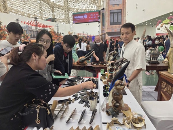 Nghệ nhân Nguyễn Văn Sử, chủ cơ sở mỹ nghệ sừng Mười Sử giới thiệu sản phẩm cho khách hàng.