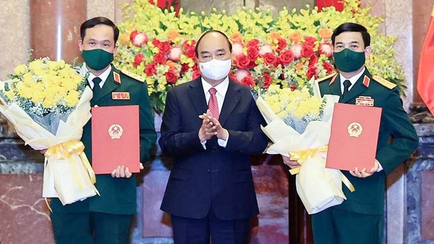 Chủ tịch nước Nguyễn Xuân Phúc trao quyết định thăng quân hàm, hoa chúc mừng Bộ trưởng Quốc phòng Phan Văn Giang (phải) và Thứ trưởng Vũ Hải Sản.