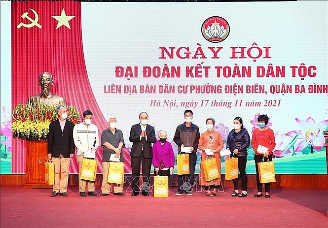 Chủ tịch nước Nguyễn Xuân Phúc trao tặng quà cho 8 hộ gia đình có hoàn cảnh khó khăn tại phường Điện Biên, quận Ba Đình. Ảnh: Phạm Kiên/TTXVN