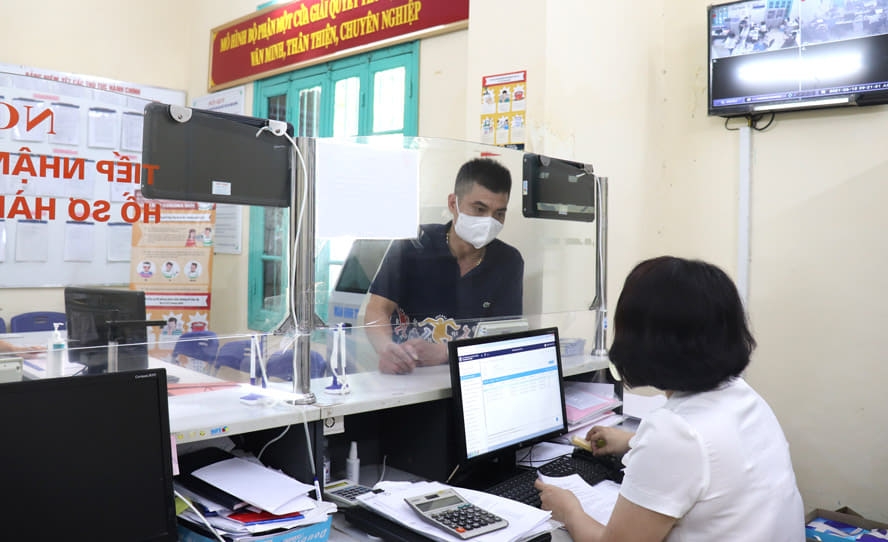 Công chức làm việc tại bộ phận “một cửa” của UBND phường Quán Thánh (quận Ba Đình)  nỗ lực giải quyết hồ sơ nhanh chóng cho công dân.