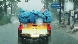 Đội phun khử khuẩn ôm lấy nhau giữa cơn mưa trắng trời ở Sài Gòn