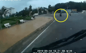 Tà áo mưa cuốn bánh xe, người đàn ông bị hất văng xuống đường