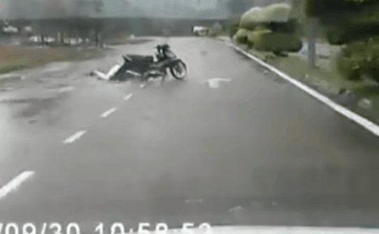 Tà áo mưa cuốn bánh xe, cô gái đi xe máy bị "quật ngã" giữa đường