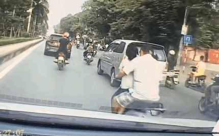 Người đàn ông chở 2 con đứng trước mặt trên xe máy