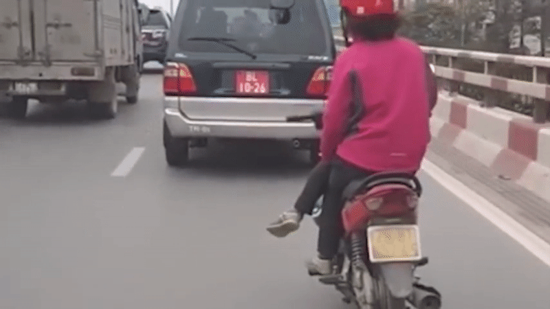 Người phụ nữ vắt chéo chân khi đi xe máy trên đường Giải Phóng