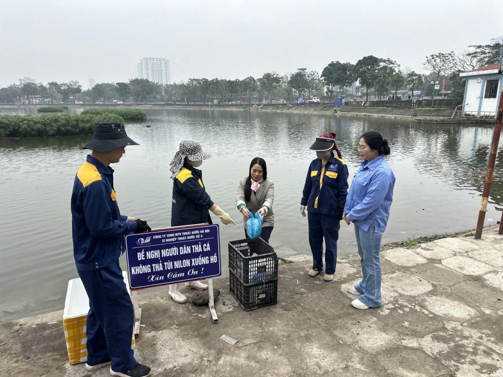 Công nhân thoát nước Hà Nội hướng dẫn, giúp đỡ người dân thả cá đúng quy định