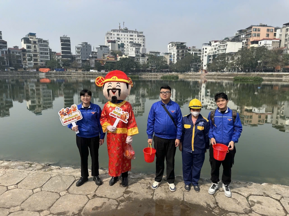 Công nhân thoát nước Hà Nội hướng dẫn, giúp đỡ người dân thả cá đúng quy định