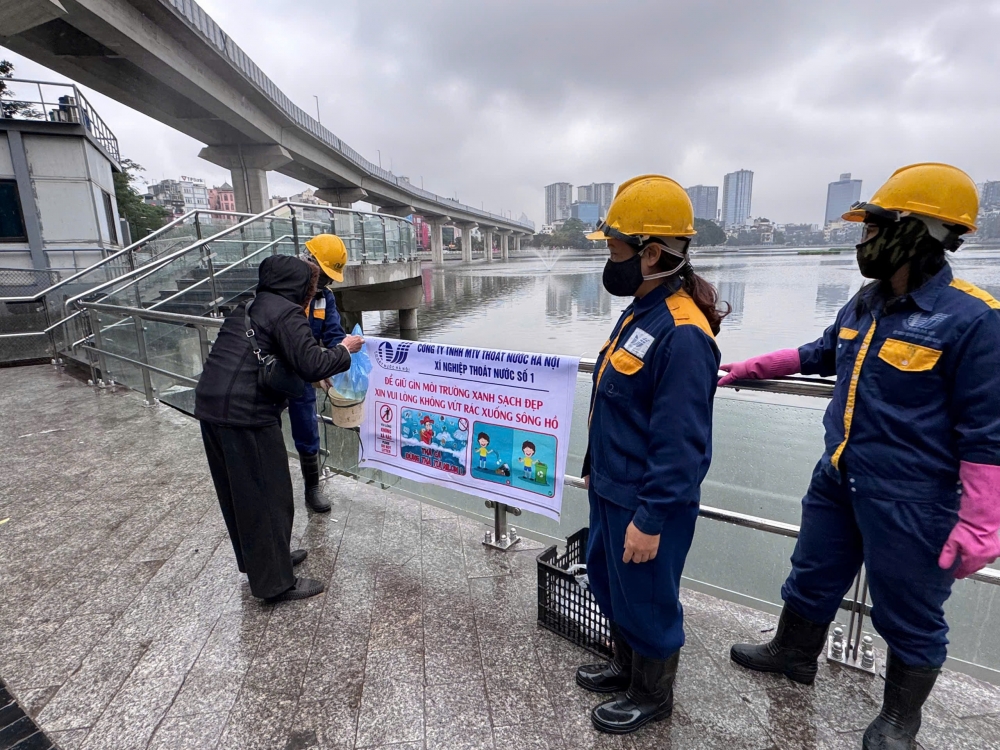 Công nhân thoát nước Hà Nội hướng dẫn, giúp đỡ người dân thả cá đúng quy định