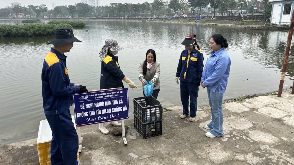Công nhân thoát nước Hà Nội hướng dẫn, giúp đỡ người dân thả cá đúng quy định