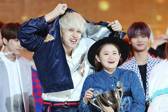 Trong một chương trình âm nhạc ngoài trời, anh chàng ga lăng nhất nhóm Ken (VIXX) đã kéo áo lên cao để che cho nữ MC Kim Shin Young.