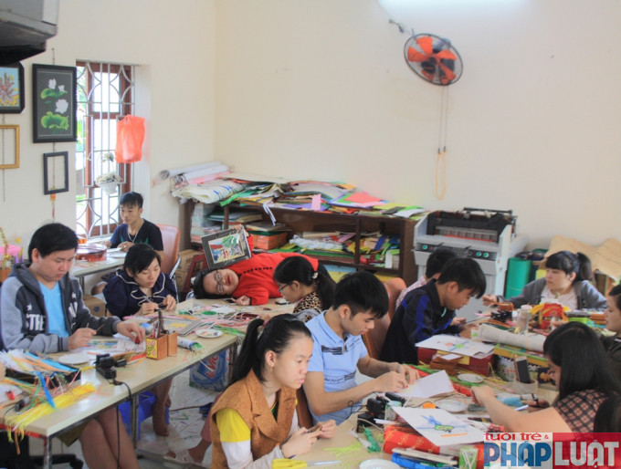 Chị Nguyễn Thị Thu Thương nằm trên bàn dạy nghề cho các em khuyết tật