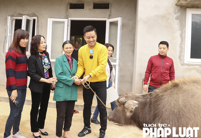 Ca sỹ Tuấn Hưng và những người bạn trao tặng một con nghé cho chị Hoàng Thị Trình ở Yên Bái.