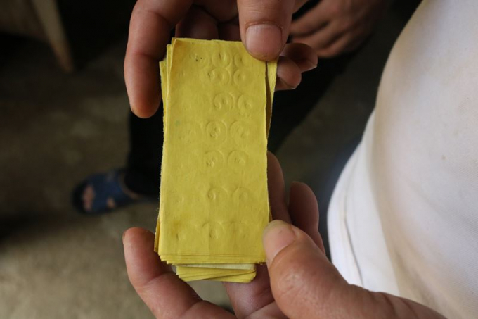 Thầy cúng đóng dấu vào những tờ giấy được cho là tiền âm phủ.