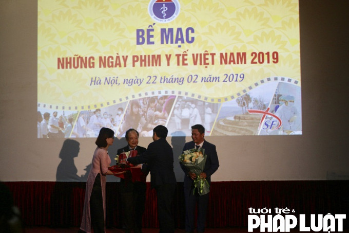 Ông Nguyễn Đình Anh trao hoa thay lời cảm ơn cho lãnh đạo hãng phim. Ảnh: Phạm Linh Chi