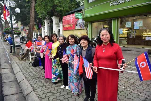 Dọc đường Lý Thường Kiệt gần khách sạn Melia, hai bên đường người dân mặc áo dài truyền thống, tay cầm cờ Mỹ và Triều Tiên vẫy chào.