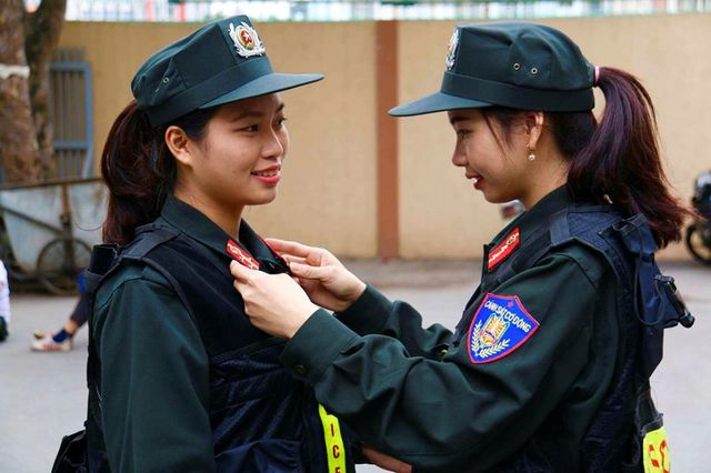 Các nữ cảnh sát cơ động giúp nhau chỉnh trang quân phục trước khi chia tay lên đường làm nhiệm vụ.