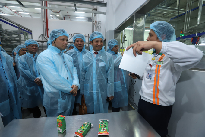 Ông Bùi Thế Cử, Phó Chủ tịch UBND tỉnh Hưng Yên và các vị khách mời lắng nghe thuyết minh về quy trình chế biến và đóng gói sản phẩm thức uống dinh dưỡng lúa mạch MILO uống liền theo công nghệ khép kín của dây chuyền.