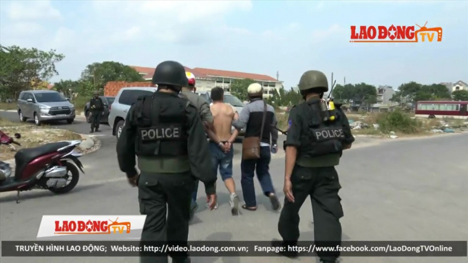 Cảnh sát áp tải một đối tượng trong đường dây ma túy do Wu Hao Shan cầm đầu