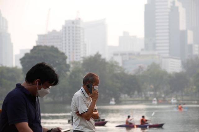  Người dân đeo khẩu trang khi các tòa nhà cao tầng bị bao phủ bởi sương mù ở thủ đô Bangkok (Ảnh: EPA)