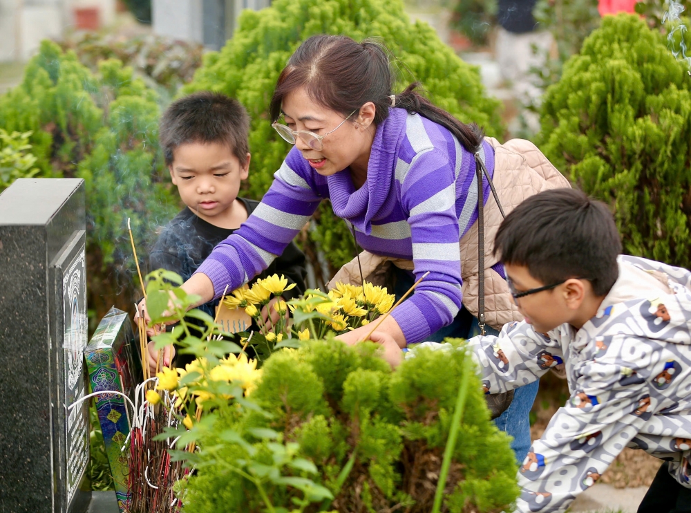 Vượt hàng nghìn km, người dân mang đào quất đi tảo mộ mời gia tiên về ăn Tết