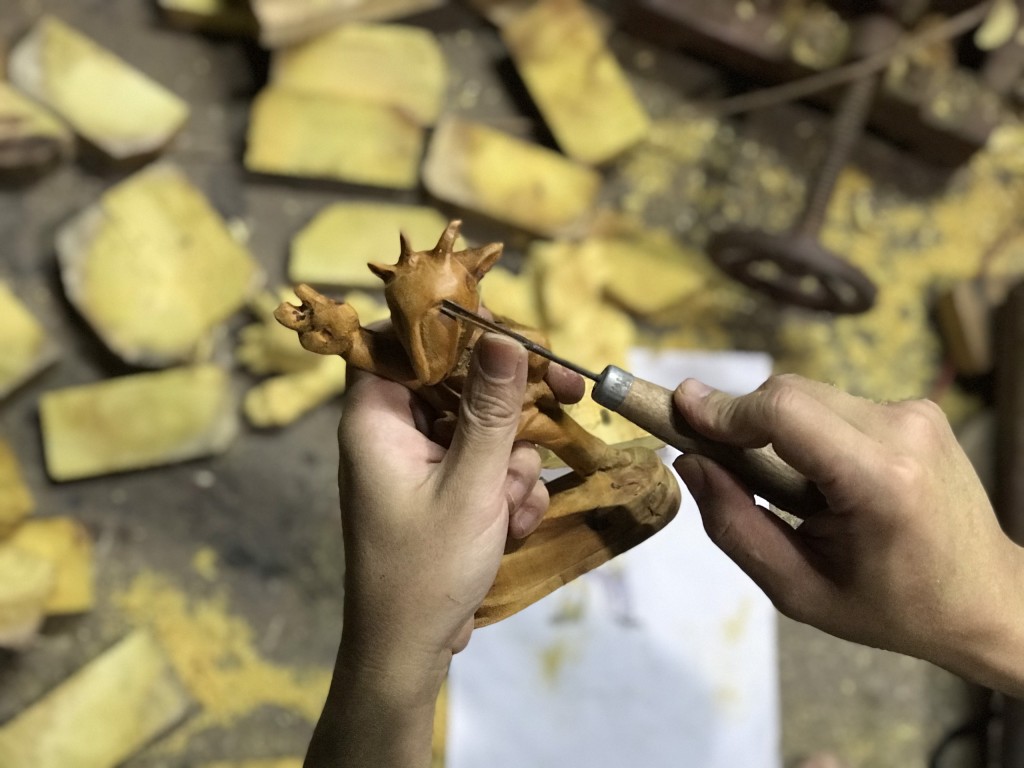 Sau khi phác thảo và cắt gỗ, nghệ nhân bắt đầu gọt dáng linh vật.