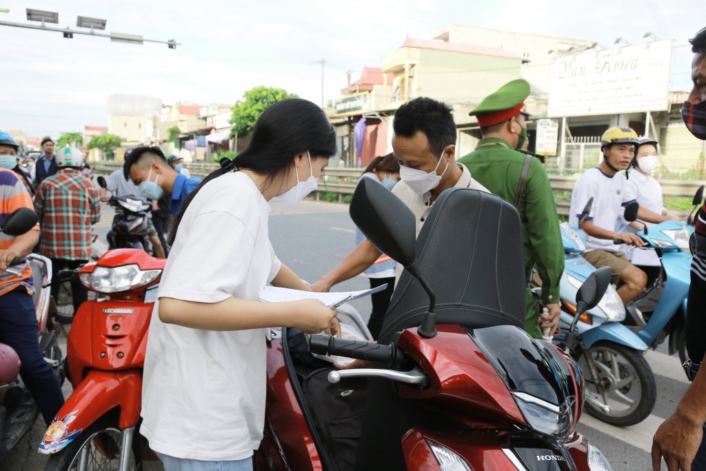 Đưa con đến điểm thi từ sớm, chú Nguyễn Quốc Hoàn kiểm tra lại giấy tờ cùng con trước khi vào thi