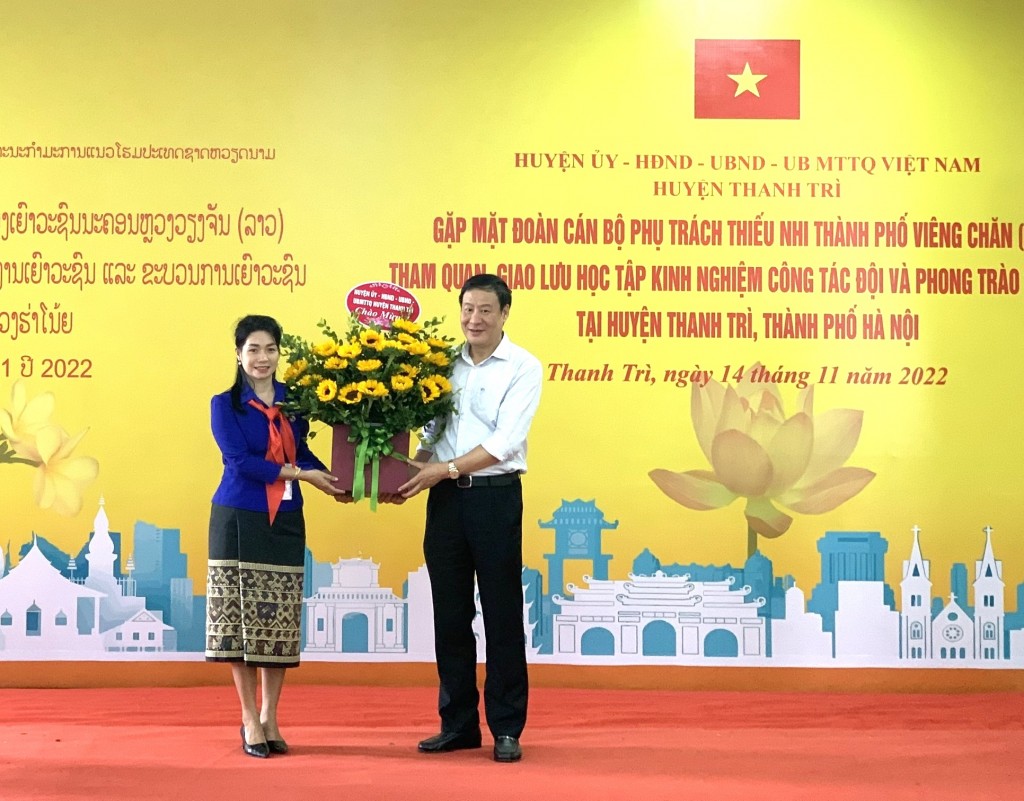 Đồng chí Lê Tiến Nhật, Thành uỷ viên, Bí thư Huyện uỷ Thanh Trì tặng hoa chúc mừng đại diện Đoàn cán bộ phụ trách thiếu nhi Lào
