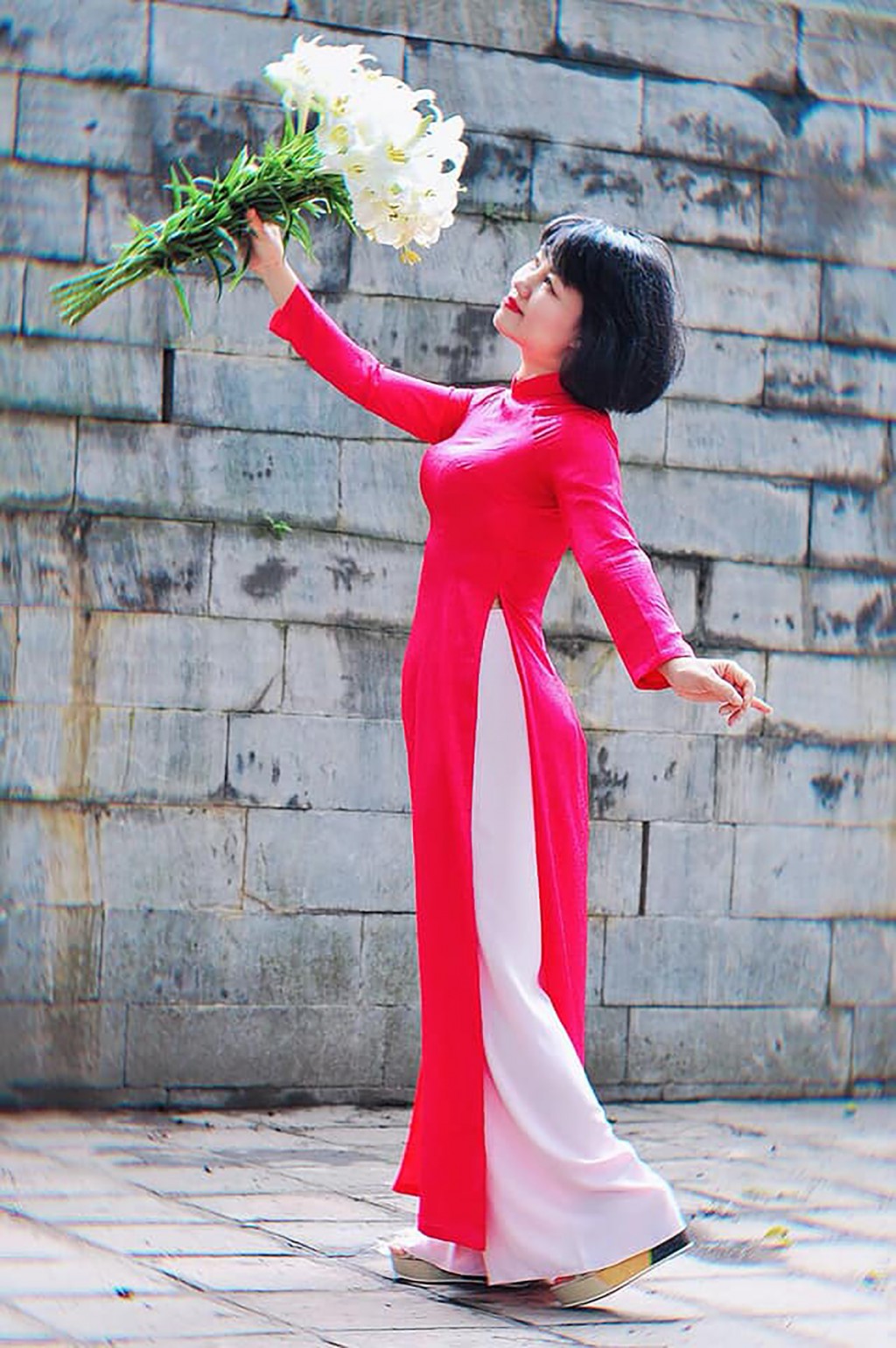 Sắc trắng tinh khôi của hoa loa kèn dường như càng tăng thêm khi sánh đôi cùng tà áo dài Việt Nam