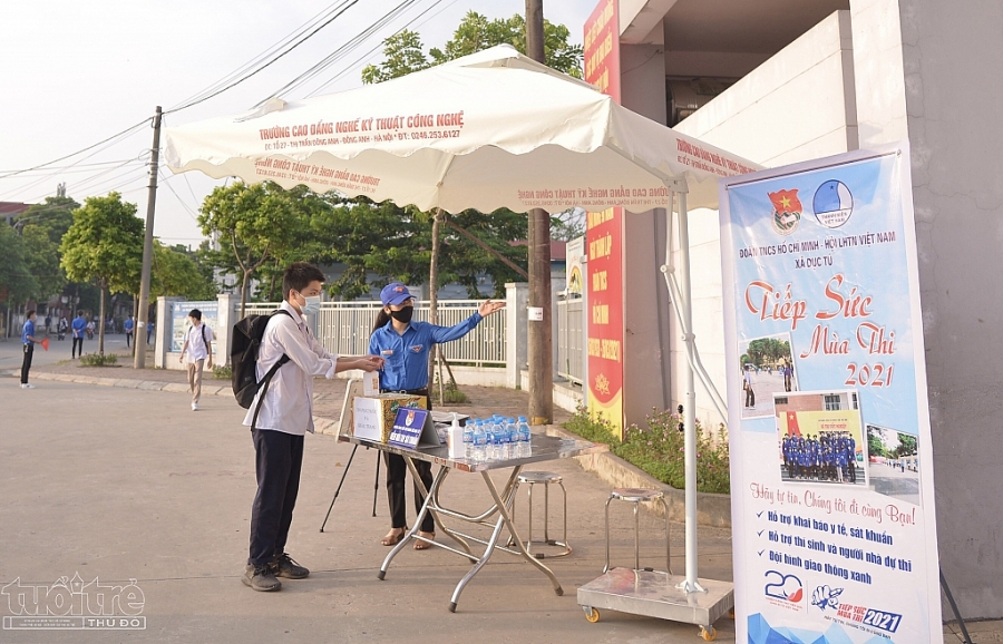 Thí sinh được tình nguyện viên Trường Cao đẳng nghề kỹ thuật công nghệ yêu cầu sát khuẩn, đeo khẩu trang đúng cách trước khi vào điểm thi