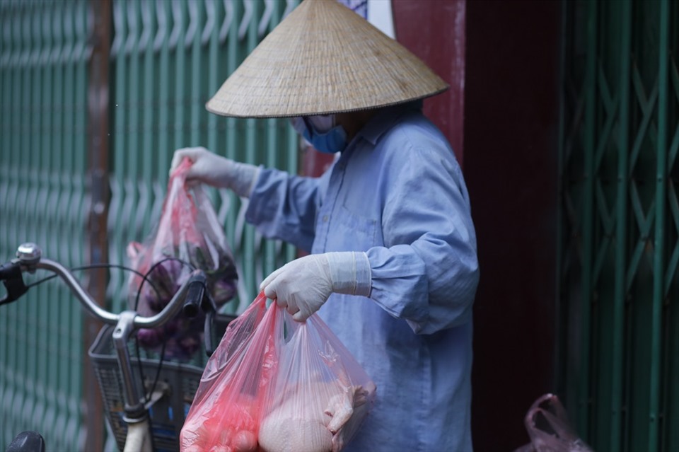 Từ sáng, nhiều người dân ở cùng chung cư với bệnh nhân 714 đã nhờ bà Phí Thị Thu mua giúp nhu yếu phẩm cần thiết trong những ngày cách ly. Ảnh: Huyền Chang