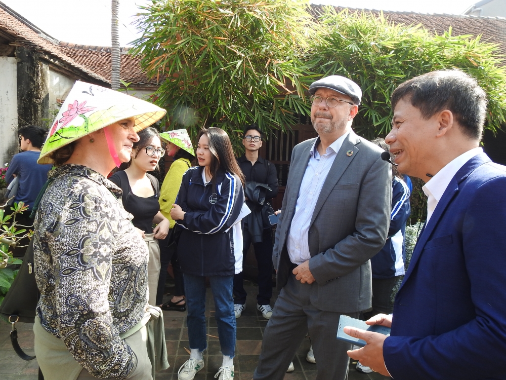 Du khách nước ngoài, các đại sứ quán hào hứng lắng nghe thuyết minh về các điểm độc đáo trong lịch sử, kiến trúc của làng cổ Đường Lâm
