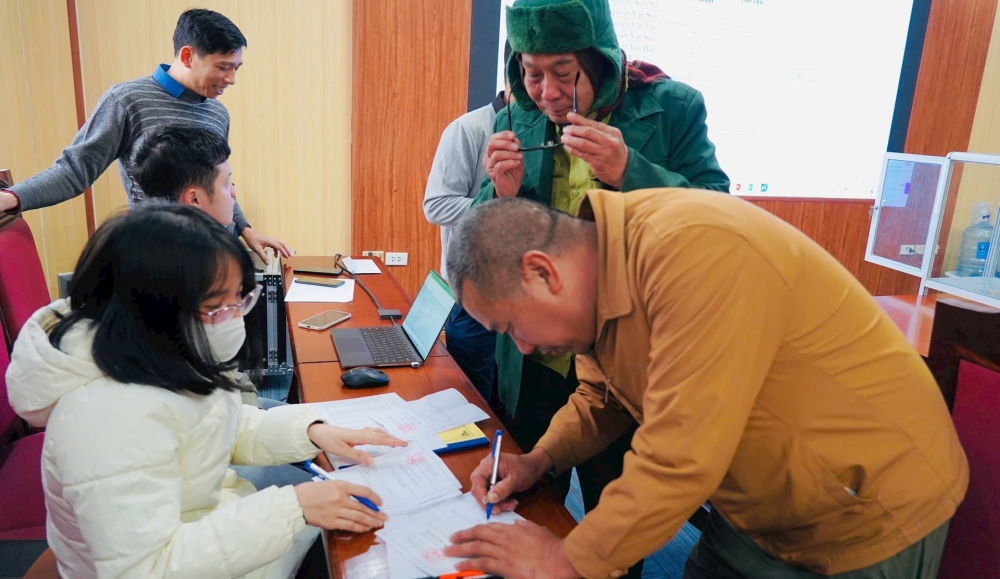 Người dân ký xác nhận nhận đất với cơ quan chức năng xã Quang Minh