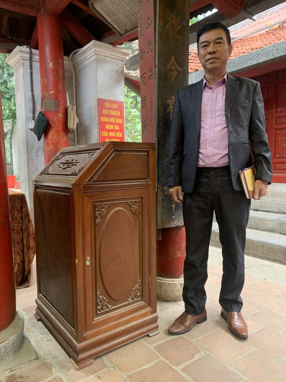 Ông Trịnh Quang Hoà (Phó Chủ tịch UBND phường Trung Hưng) bên cạnh hòm công đức đã được khoá cản thận