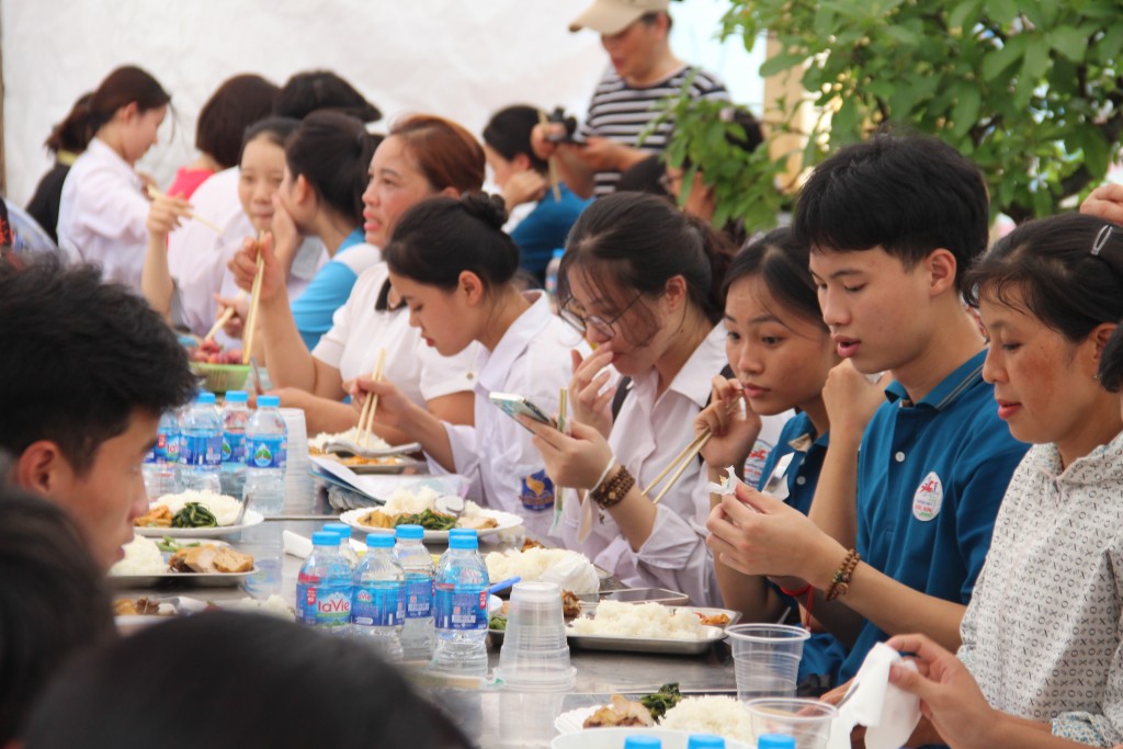 Sĩ tử và phụ huynh dùng cơm trưa tại sân nhà chị Lê Thị Hoa