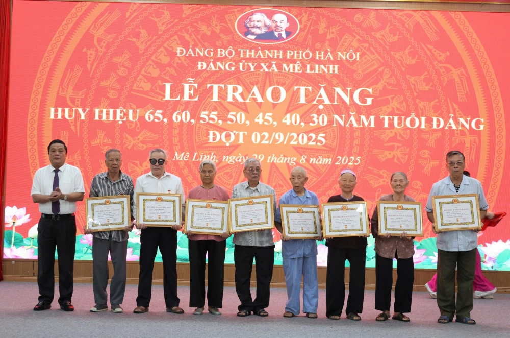 Phó Bí thư Đảng ủy, Chủ tịch UBND xã Mê Linh Trần Thanh Hoài trao Huy hiệu 60 năm tuổi Đảng tặng các đảng viên
