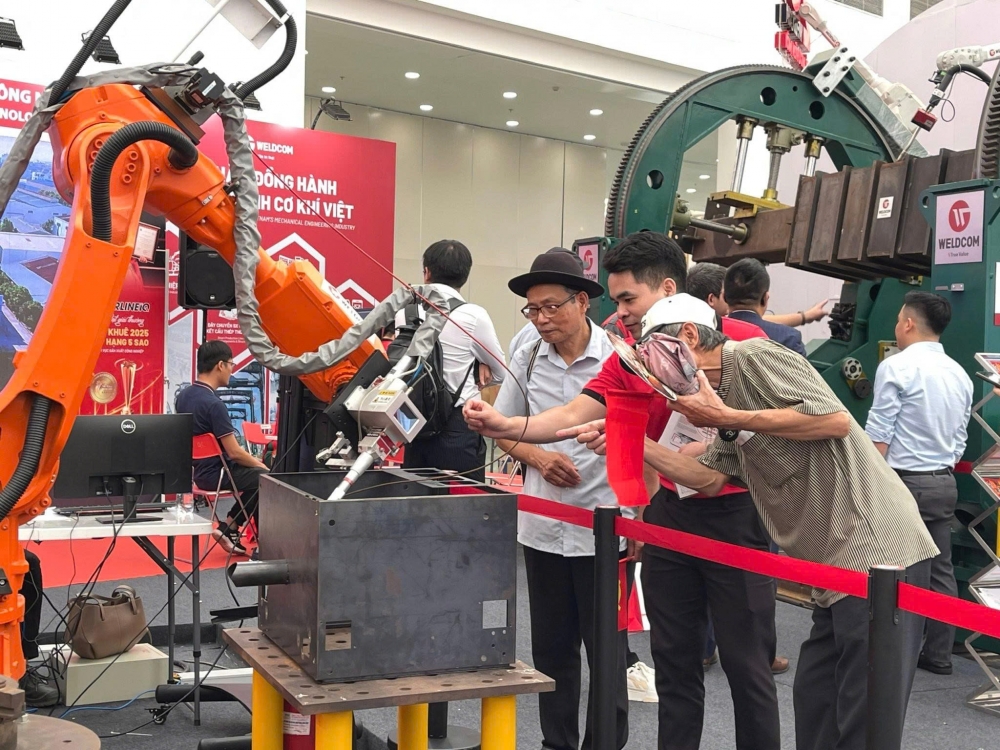 Khách tham quan lắng nghe giới thiệu về sản phẩm robot hàn tự động của Công ty cổ phần Công nghiệp WELDCOM. Ảnh: Thu Trang