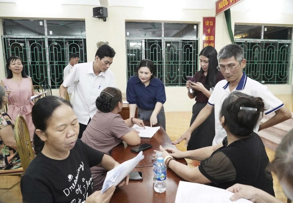 Tổ công tác của xã Thường Tín hướng dẫn, hỗ trợ người dân cài đặt ứng dụng Etax-Mobile để thu thuế sử dụng đất phi nông nghiệp năm 2025.