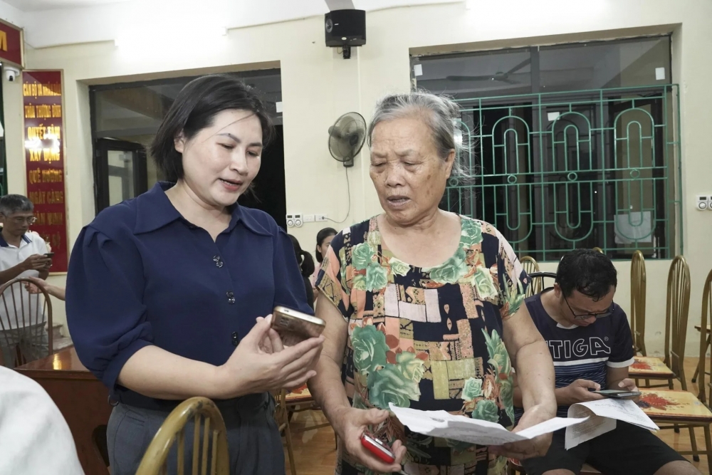 Phó Chủ tịch UBND xã Thường Tín Uông Thị Phượng hướng dẫn người dân sử dụng Etax - Mobile để thu thuế sử dụng đất phi nông nghiệp.