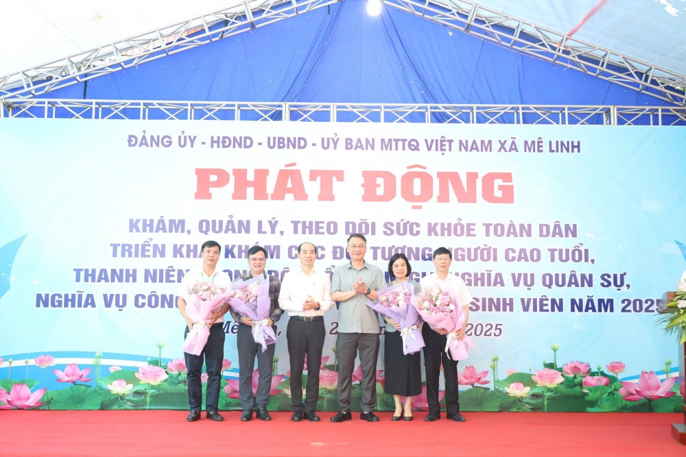 Phó Giám đốc phụ trách Sở Y tế Hà Nội Nguyễn Đình Hưng và Bí thư Đảng ủy xã Mê Linh Nguyễn Anh Tuấn tặng hoa cho đại diện các đơn vị y tế tham gia khám sức khỏe cho Nhân dân.