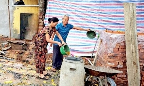 Thành viên đội xung kích phường Quang Trung hướng dẫn người dân xử lý các dụng cụ chứa nước 