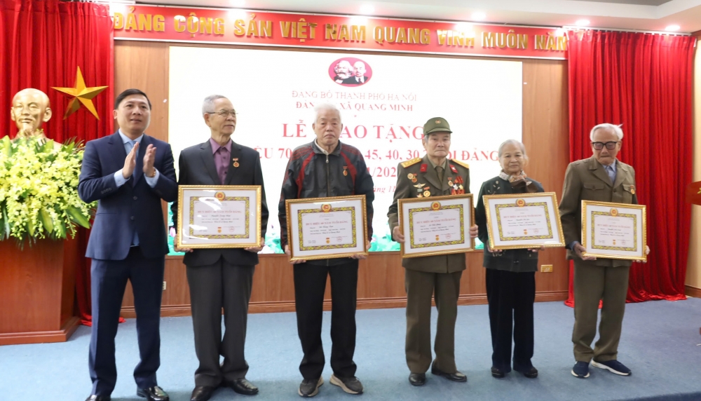 Bí thư Đảng ủy xã Quang Minh Nguyễn Thanh Liêm trao huy hiệu đảng cho các đảng viên lão thành. 