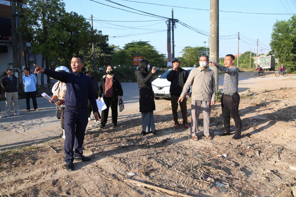 Cán bộ phòng Kinh tế xã Quang Minh bàn giao đất ngoài thực địa cho người dân.