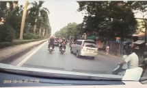 Ông bố chở 2 con đứng trước mặt trên xe máy