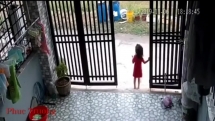 Người phụ nữ vào trong sân giật điện thoại trên tay bé gái